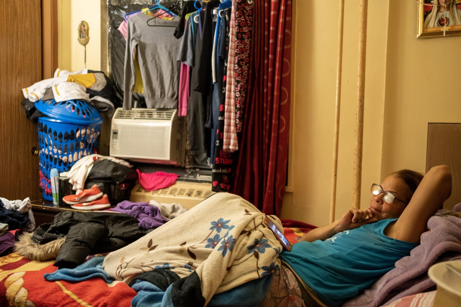 Maria Fernandez in her bedroom. The window is covered in plastic to keep out the cold. Photo by Antonio di Caterina.