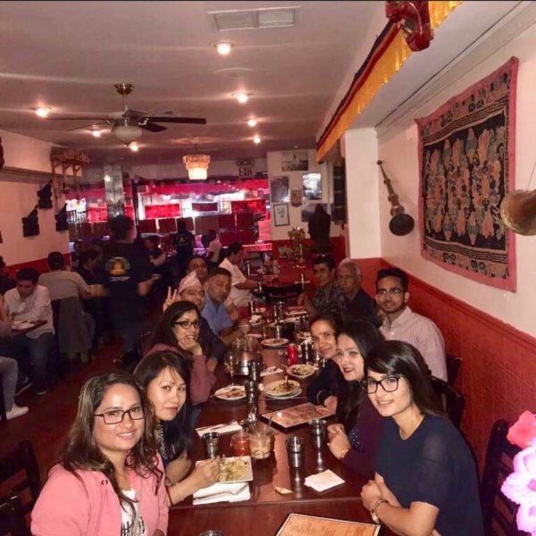 Picture of inside of restaurant with a large party of diners at a long table