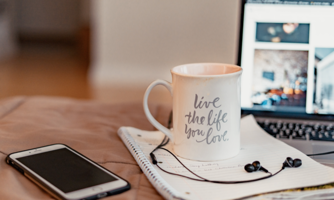 iPhone, coffee cup, headphones and computer