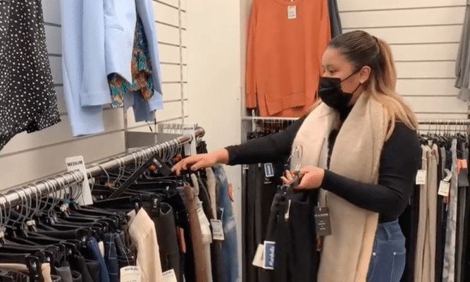 Woman and rack of clothes in a store
