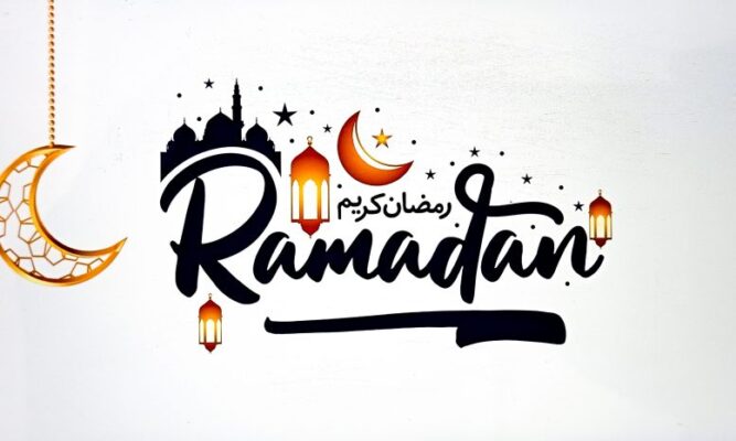 This is a public domain white sign with black letters spelling Ramadan. We also see two orange and yellow quarter moons (one appearing to dangle from a chain), and three lanterns and some scattered black stars (one orange/yellow star). Above the capital R (first letter of Ramadan) there's a black silhouette image of some domed temples and a tall tower - I think possibly representing Mecca.