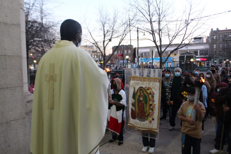 Father receives parishioners in front of the church.