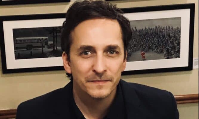 To provide context and an image of the person discussed.