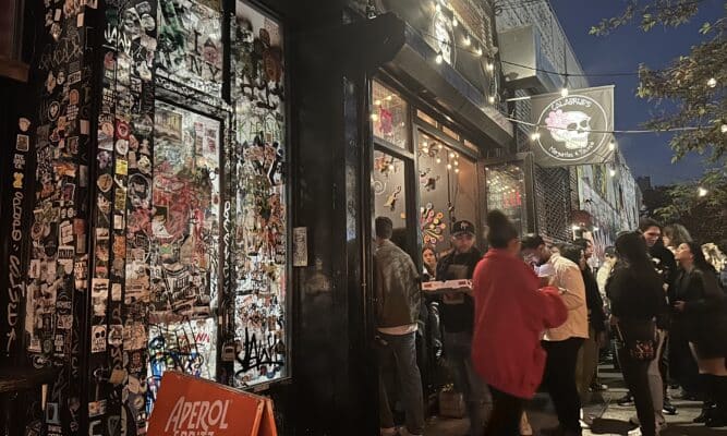 Bar goers congregated in front of a bar.